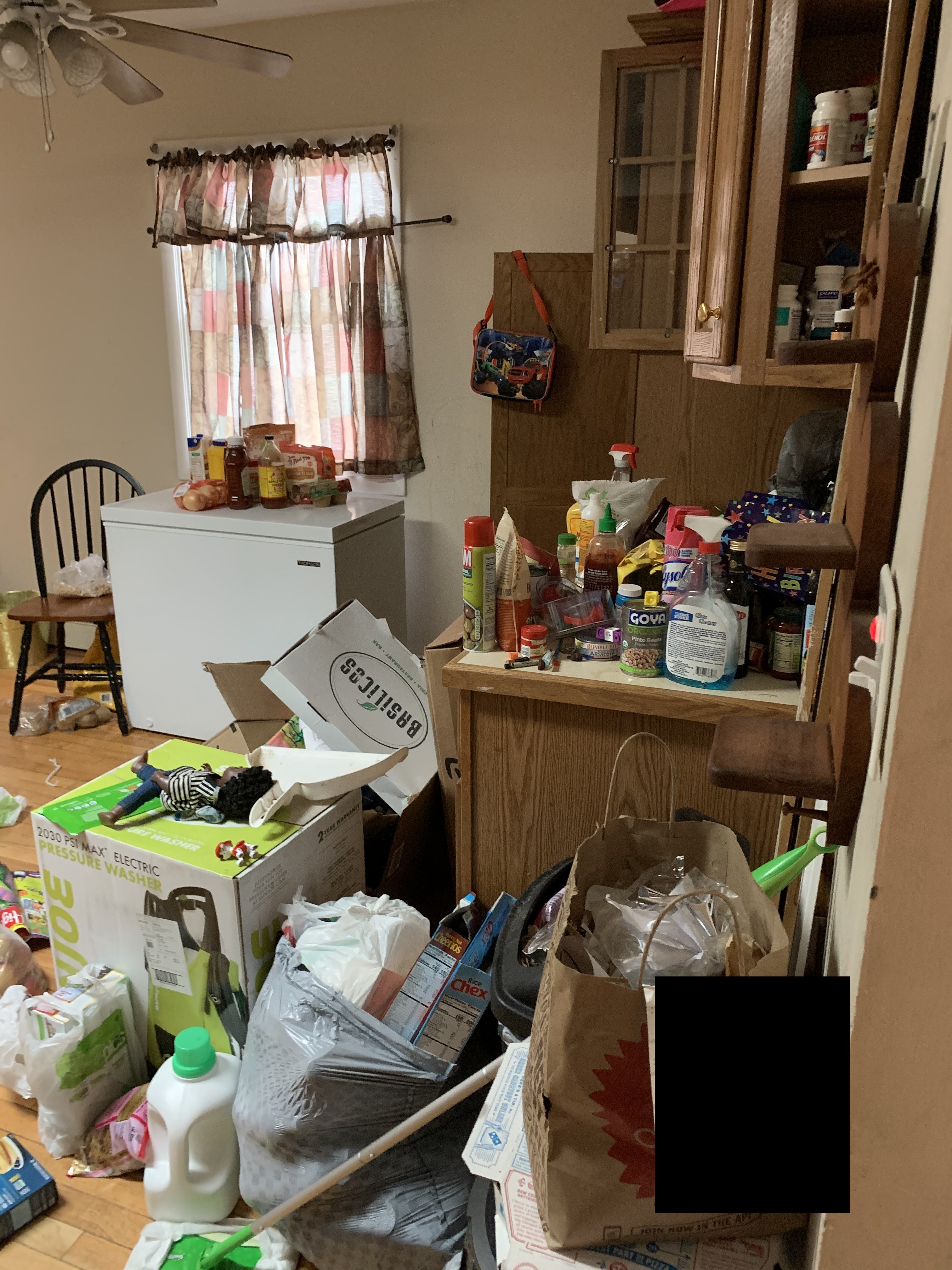 Kitchen area before cleaning - clutter and boxes